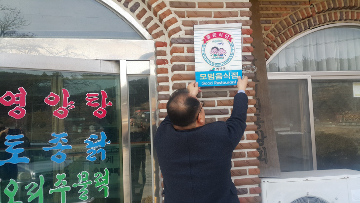 3.모범음식점으로 지정된 식당에 표지판을 부착하고 있다